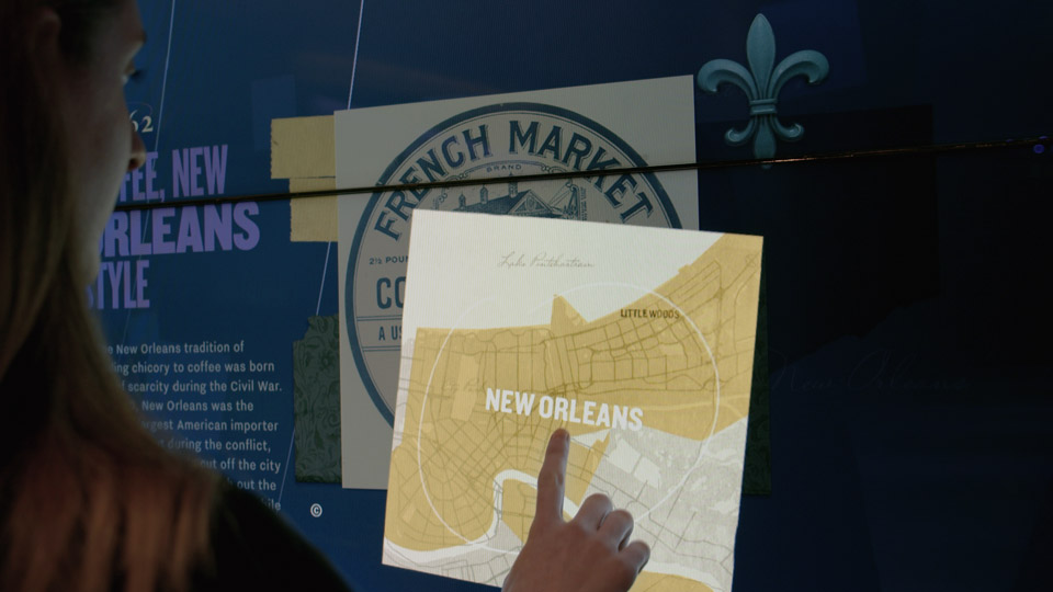 Visitor opening a French Market card Visitor opening a French Market card on the touch wall, revealing a hand-drawn New Orleans map
