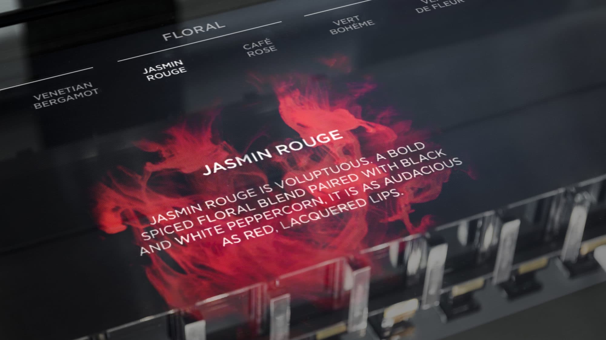 Jasmin Rouge screen with the red ink bloom, fragrance description and scent family navigation