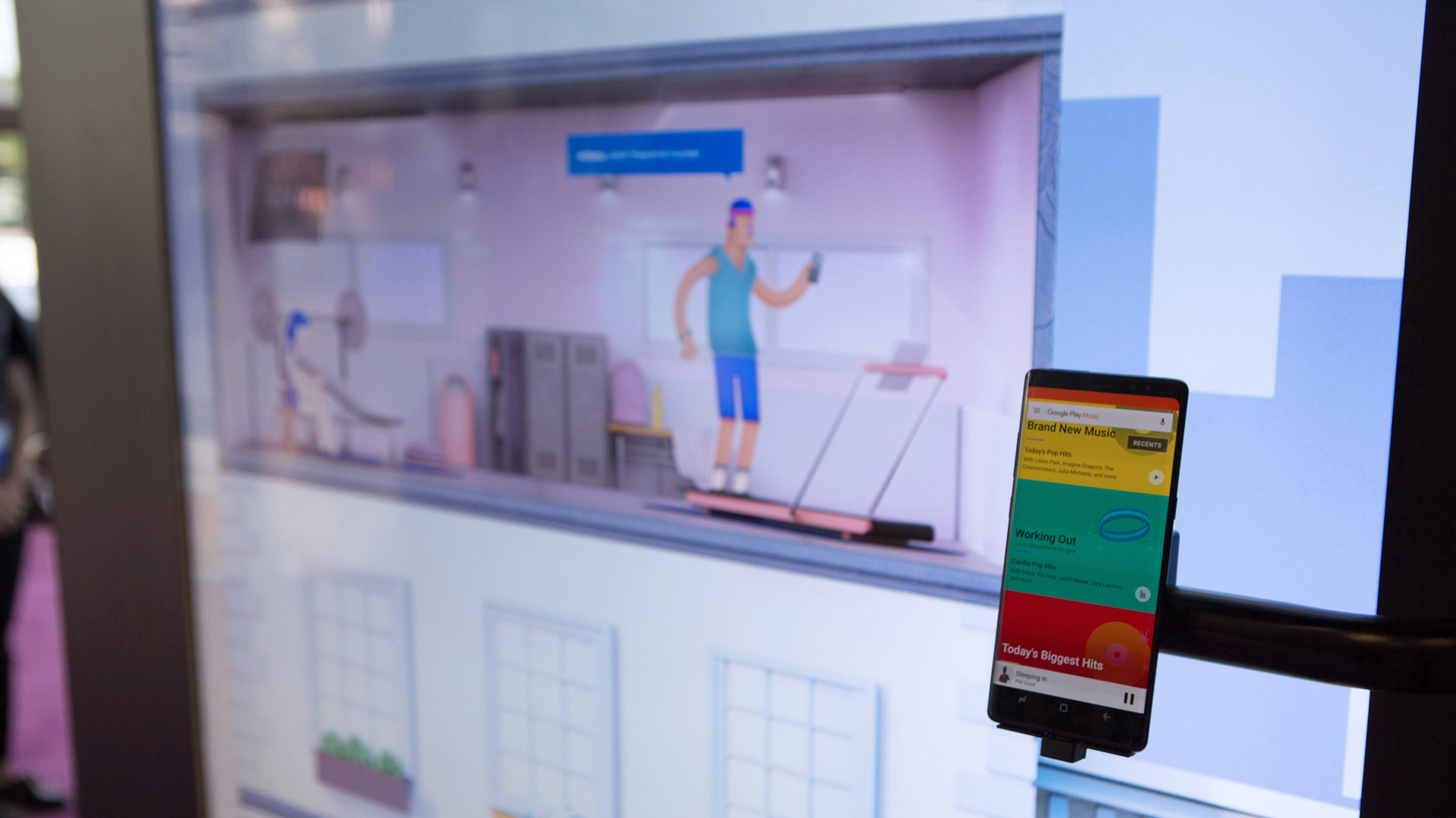 Home workout scene on the wall Close-up of the wall screen showing a home workout scene with a phone mounted beside it